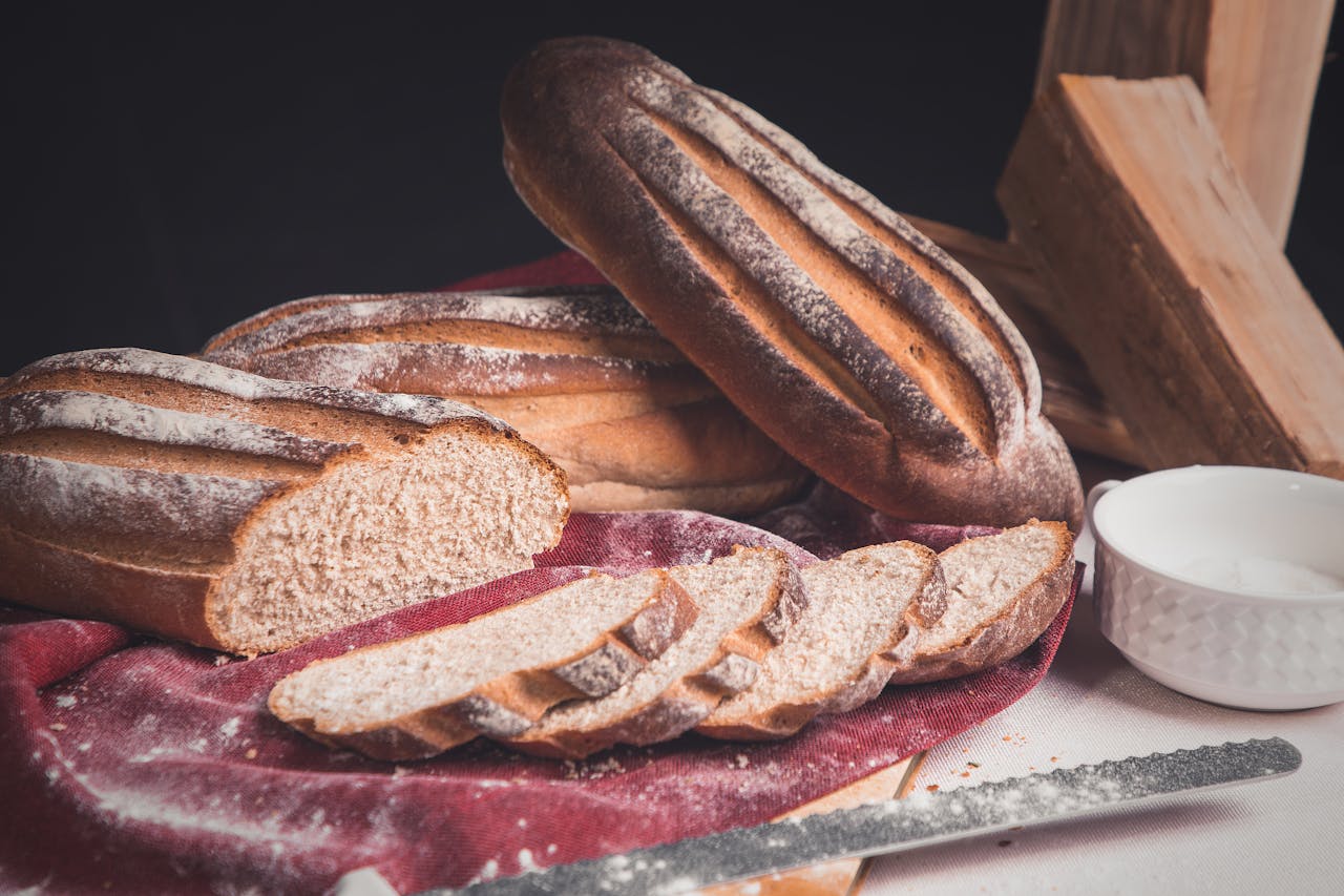 Sliced homemade sourdough bread on rustic cloth, perfect for food photography.