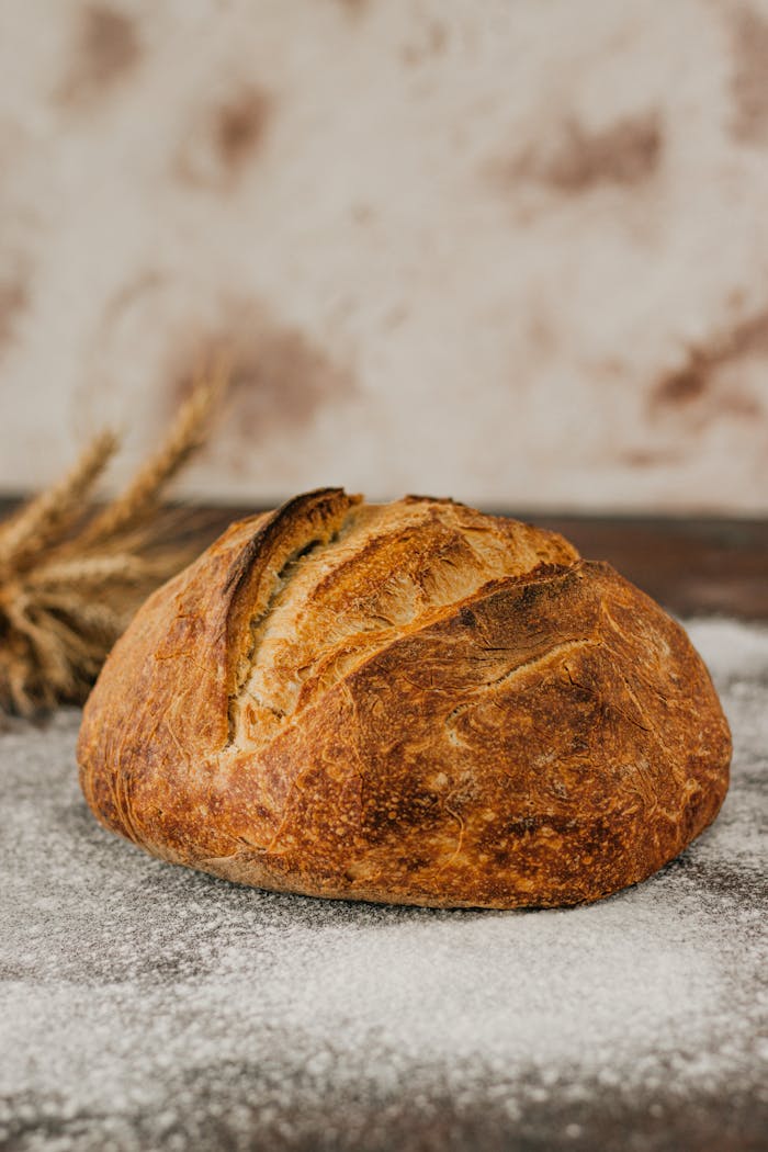 Close-up of a rustic artisan bread loaf on a flour-dusted surface.